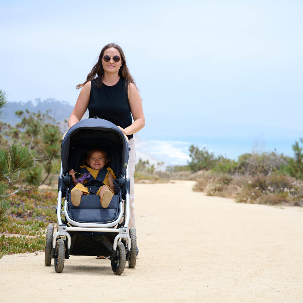 
                      
                        Picture of mother pushing toddler on dirt trail along coast. New Collection 2022 - Global
                      
                    