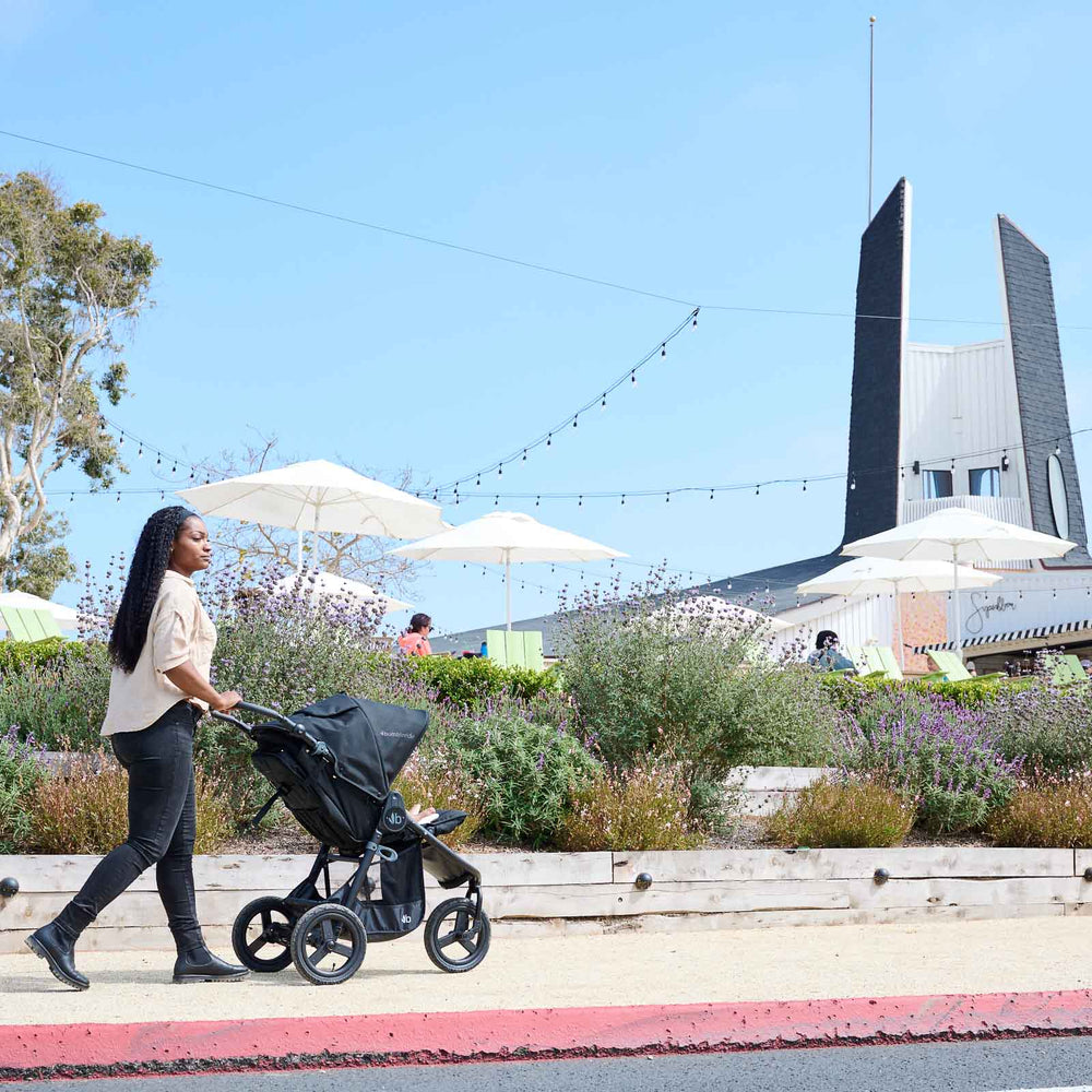 
                      
                        Mother pushing Bumbleride Indie in Matte Black in front of flowers on sidewalk in front of store in background - New Collection 2022 - Global
                      
                    