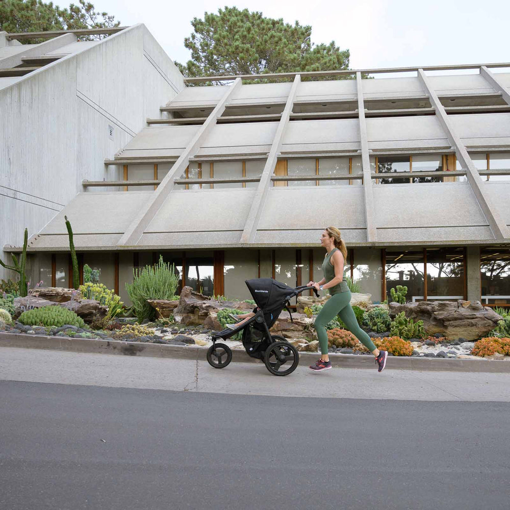 
                      
                        Mother jogging with Bumbleride Australia Speed Jogging Stroller in Black on sidewalk with cement building and succulent plants in background
                      
                    